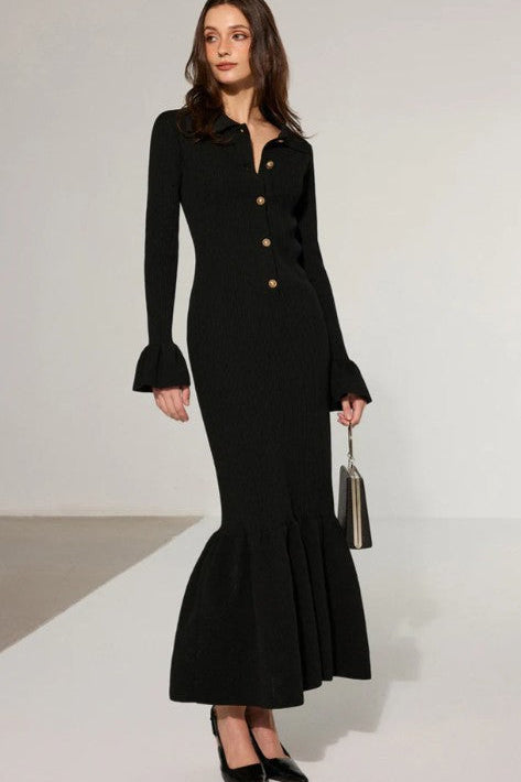 Woman wearing a black dress with a fitted bodice and flared skirt on a white background