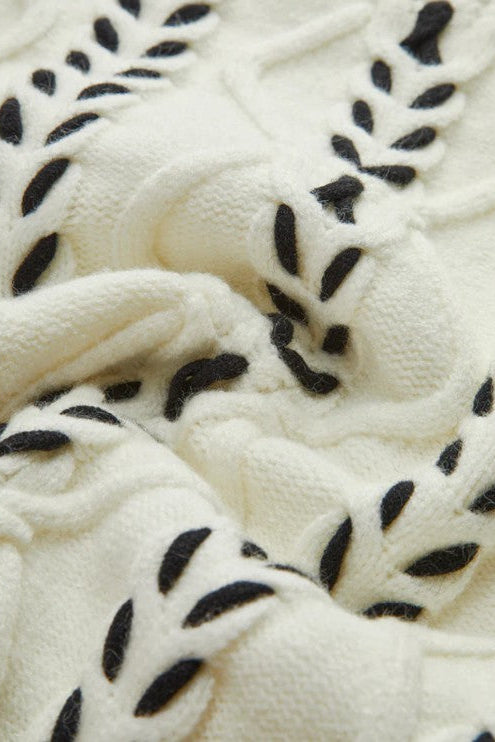 Close-up of a textured white fabric with black leaf patterns
