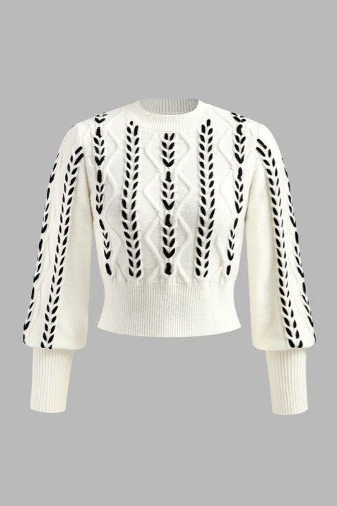 White sweater with black pattern on a gray background