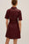 Burgundy dress worn by a person on a plain background