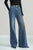 Blue flared jeans worn by a person on a light gray background